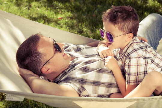 Father and son lying on hammock in the garden.