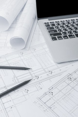 black pencil and computer laptop on architectural drawing paper for construction