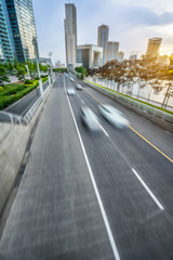 Fototapeta na wymiar motion blurred car with modern buildings background