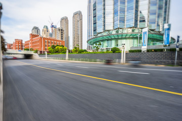 Fototapeta na wymiar motion blurred car with modern buildings background