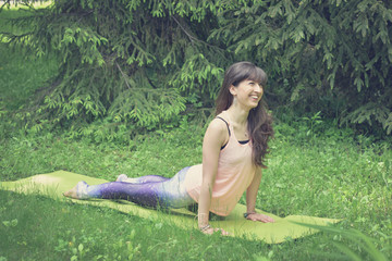 Woman doing yoga exercises outdoors in the city.Beautiful brunette fit young woman wearing sportswear practicing yoga urban style.Working out,fitness,sport,training and lifestyle concept