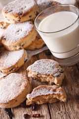 Freshly baked Welsh cakes with raisins and milk close-up. vertical
