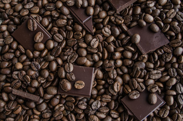Broken slices of chocolate and coffee beans