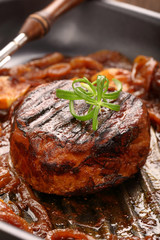 Grilled pork chop with onion on the pan on wooden background