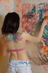 beautiful girl artist paints on the wall