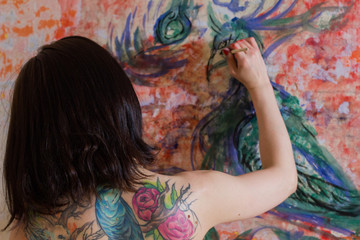 beautiful girl artist paints on the wall