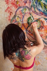 beautiful girl artist paints on the wall