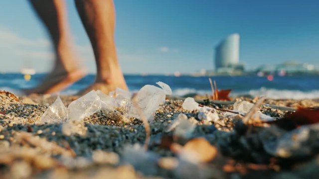 garbage on the beach, tourists feet are in the sand. Barcelona, Spain