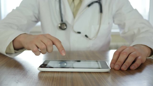Doctor Using tablet pc and typing prescription