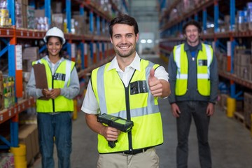 Worker with thumb up wearing yellow safety vest