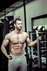 Obraz na płótnie Canvas Man showing abs in gym