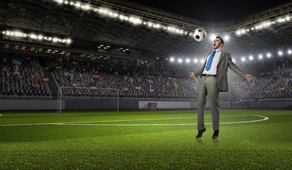 Businessman kicking ball . Mixed media