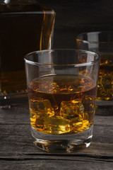 Whisky in two glasses on a dark wooden background