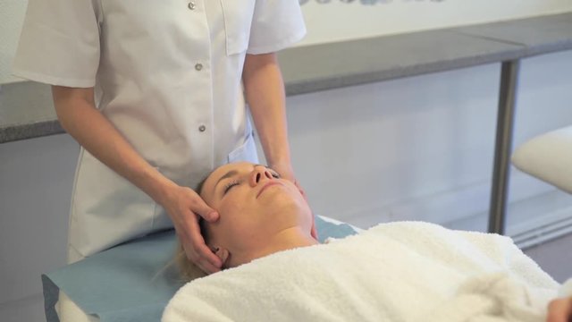 View of a Young attractive masseuse doing a capillariy massage