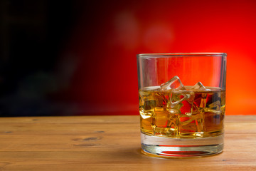 Glass of Whisky With Ice on a Wooden Table