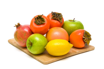 Naklejka na ściany i meble ripe fruit on a wooden cutting board closeup on white background