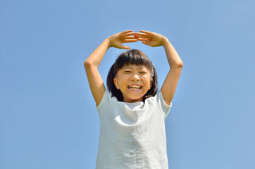 青空でマルのジェスチャーをする女の子