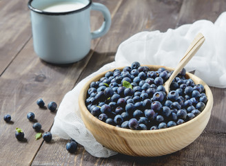 Fototapeta na wymiar Blueberries and cup of milk on a wooden table