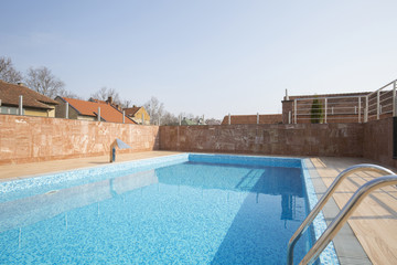 Fototapeta na wymiar Outdoors swimming pool in front of building