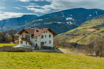 House next to the pasture on mountains background,