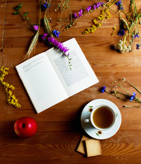 Still life in a rustic style with vintage book, wild flowers, a