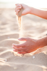 Man adding coarse sand to a heap with his hands. Very shallow de