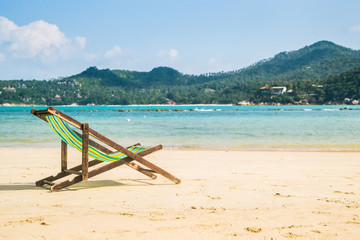 Lounge chairs on a tropical beach at summer.