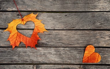 Autumn leaves. Autumn leaves hearts on wood background.