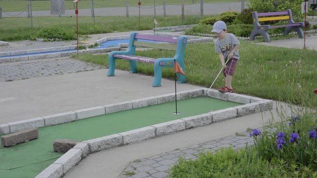 kid boy child playing mini putt golf