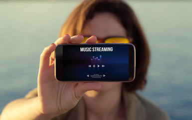 woman showing music streaming on phone screen