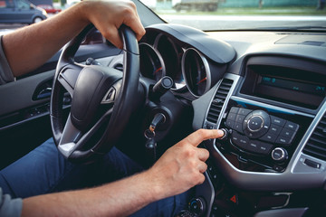 Car dashboard. Radio closeup. Man sets radio