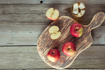 apples on a cutting board and glass of juice