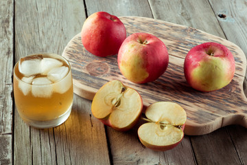 glass of juice and apples on a cutting board