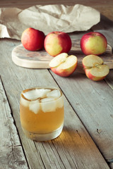 glass of juice and apples on a cutting board