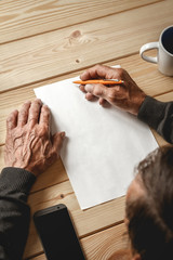 The old man wrote a testament, sitting at a wooden table