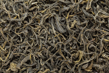 Organic Green Tea (Camellia sinensis) dried long leaves. Macro close up background texture. Top view.