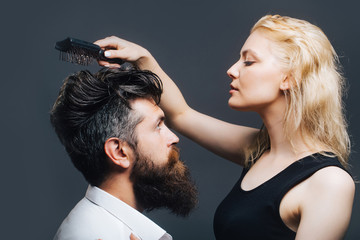 blonde hairdresser combing bearded man