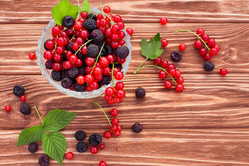 Fresh mixed fruit with  blackberry and redcurrant on wooden background.
