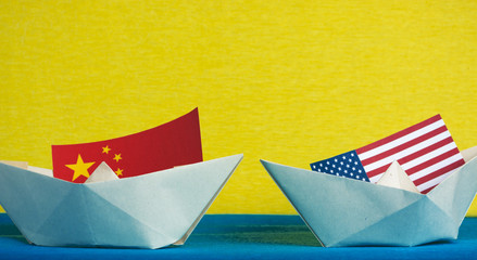 paper ship with Flags of USA and China. conflict in South China Sea, concept shipment or free trade agreement and membership.
