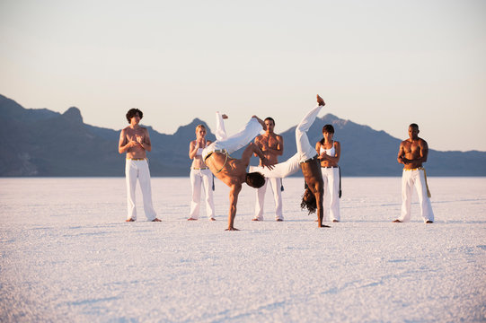 People practicing capoeira in desert