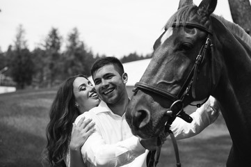 Obraz premium A newlywed couple standing next to a horse