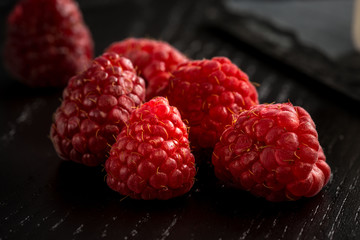 Lamponi rossi su un tavolo di legno antracite