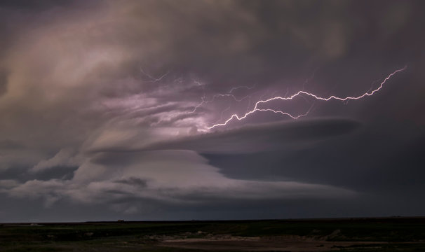 Lightning shoots out of the updraft into the rain of the front flank downdraft of this supercell