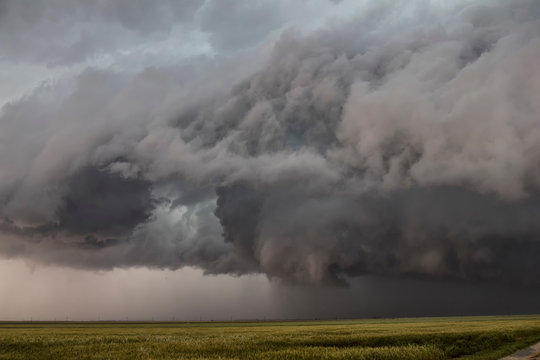 Funnel cloud hovers over a country road while intense updrafts ascend
