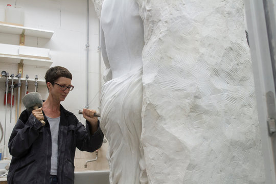 Stonemason using chisel and mallet to create sculpture