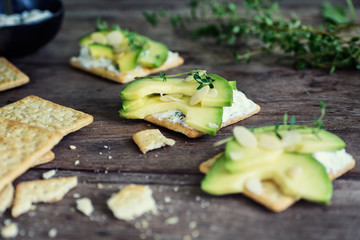Healthy crackers with sour cream, thyme and avocado