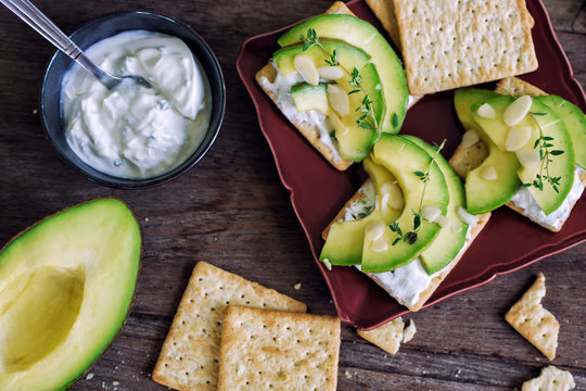 Healthy Crackers In Plate With Sour Cream, Thyme And Avocado