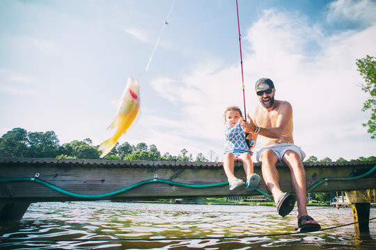 Father and daughter reeling in fish at Lake Jackson, Atlanta, Georgia, USA