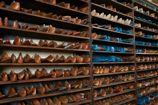 Rows of old wooden shoe lasts on shelves in traditional shoe shop