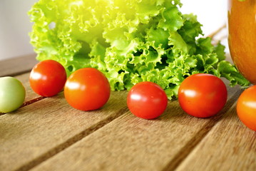 fresh green lettuce salad and tomatoes on wooden background